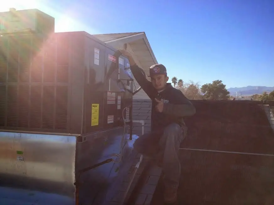 HVAC technician performing AC Tune-Up on a rooftop unit in Clayton